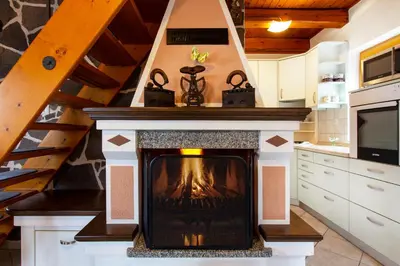 a fireplace in the middle of a kitchen at Quiet family house Butterfly place in Dob