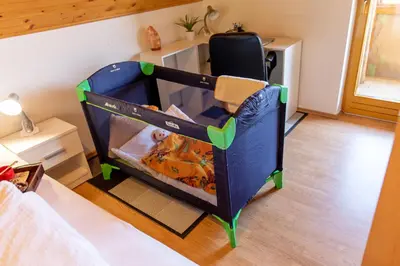 a baby in a crib in a bedroom at Quiet family house Butterfly place in Dob