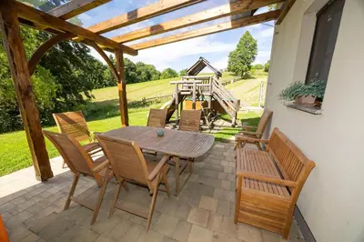a wooden table and chairs on a patio with a view at Tourist Farm Rajšp in Benedikt v Slovenskih Goricah