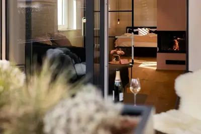 a living room with a couch and a wine glass at La Villa Ljubljana in Ljubljana