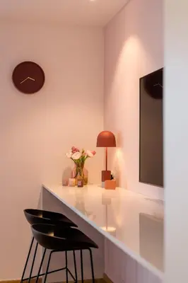 a dining table with a vase of flowers and a lamp at La Villa Ljubljana in Ljubljana