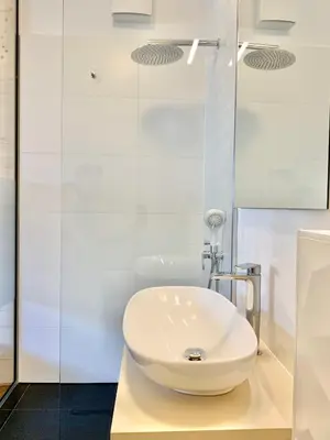 a bathroom with a white sink and a shower at Kamr’ca in Ljubljana