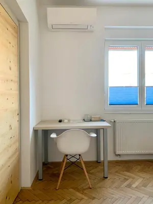 a desk and a chair in a room with a window at Kamr’ca in Ljubljana