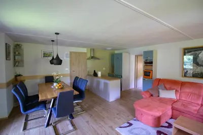 a living room with a red couch and a table at Apartmaji Nena in Ročinj