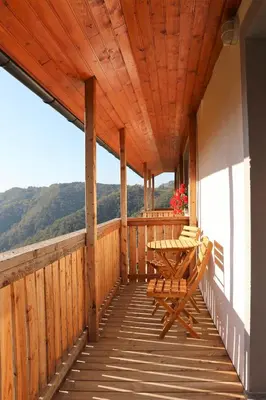 a wooden porch with a table and chairs on it at Apartmaji Nena in Ročinj