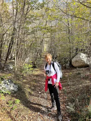 a woman standing on a trail with a camera at Apartmaji Nena in Ročinj