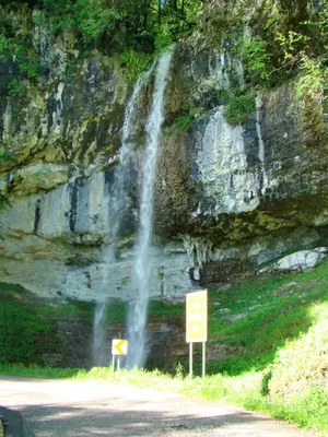 a waterfall on the side of a mountain next to a road at Apartmaji Nena in Ročinj