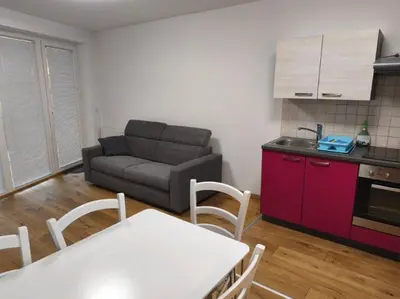 a living room with a couch and a table and a kitchen at Apartma Ajda in Moravske Toplice
