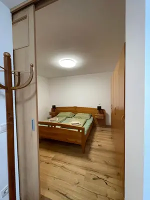 a bedroom with a bed and a wooden floor at Apartma Ajda in Moravske Toplice