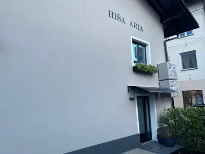 a white building with a sign on the side of it at Apartment Aria in Kobarid