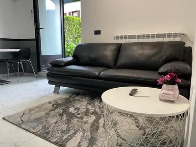 a black leather couch sitting in a living room with a table at Apartment Aria in Kobarid