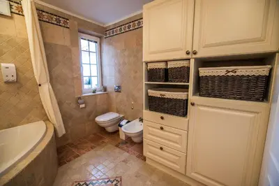 a bathroom with a tub and a toilet and a sink at Villa Zupan with Hot Tub in Škocjan