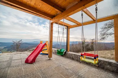 a play area with swings in a house at Villa Zupan with Hot Tub in Škocjan