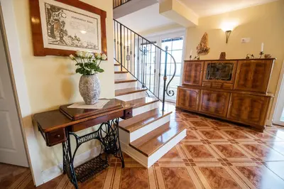 aoyer with a staircase and a vase of flowers on a table at Villa Zupan with Hot Tub in Škocjan