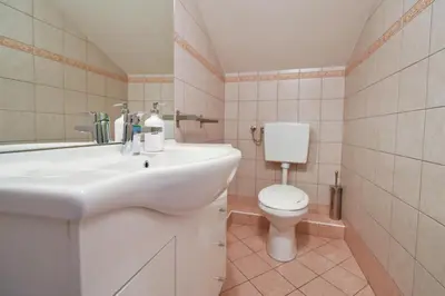a bathroom with a white sink and a toilet at Hostel X Point in Kobarid