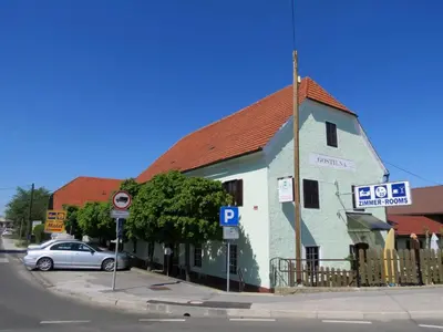 a blue and white building with a car parked in front at Motel Divjak in Spodnje Hoče