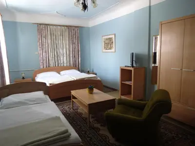 a hotel room with two beds and a chair at Motel Divjak in Spodnje Hoče
