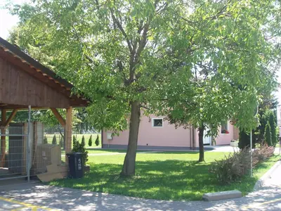a tree in a yard next to a building at Motel Divjak in Spodnje Hoče