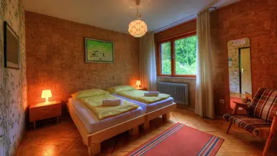 a bedroom with a bed and a couch and a window at Guesthouse Marko in Bled
