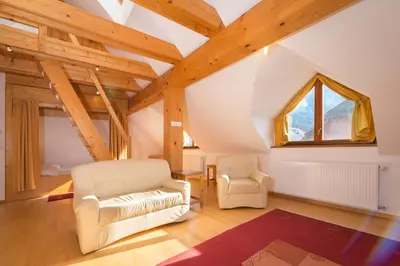 a living room with two white chairs and a window at Koritnica Apartments in Bovec