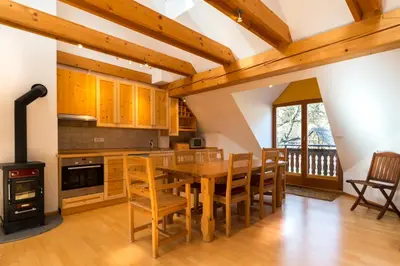 a kitchen with a wooden table and chairs and a stove at Koritnica Apartments in Bovec