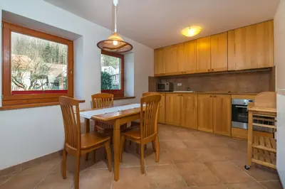 a kitchen with a wooden table and chairs at Koritnica Apartments in Bovec