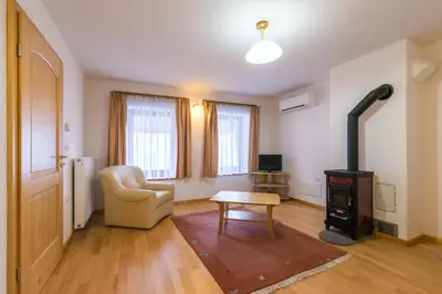 a living room with a wood stove and a chair at Koritnica Apartments in Bovec