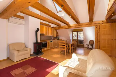 a living room with a white couch and a kitchen at Koritnica Apartments in Bovec