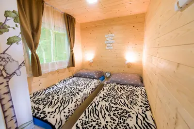 two beds in a sauna with a window at Glamping Krone Kolpa Heaven in Adlešiči