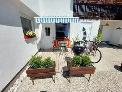 a patio with threeotted plants and a table and a bike at Apartments Karin in Bled