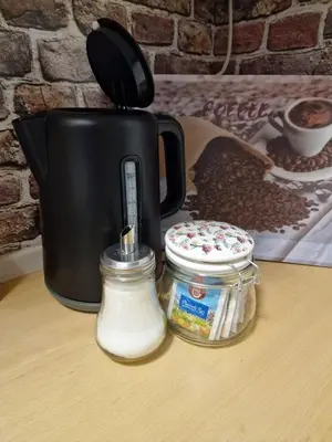 a black coffee pot sitting on a table with coffee beans at Apartments Karin in Bled