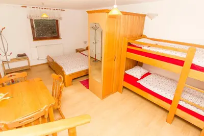 a living room with two bunk beds and a table at Tourist Farm Pri Martinovih in Krška Vas