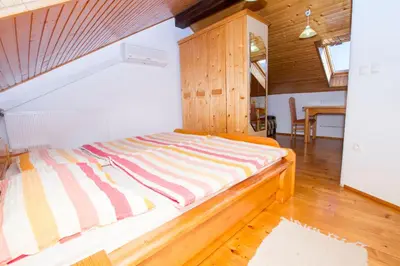 a bed with a striped blanket on it in a room at Tourist Farm Pri Martinovih in Krška Vas