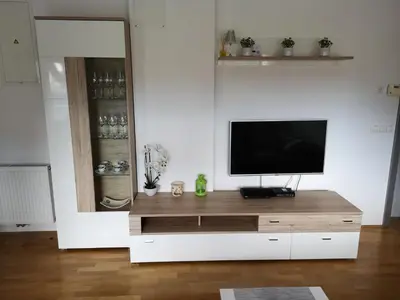 a living room with a television on a wooden entertainment center at Apartma Lucijana in Mojstrana