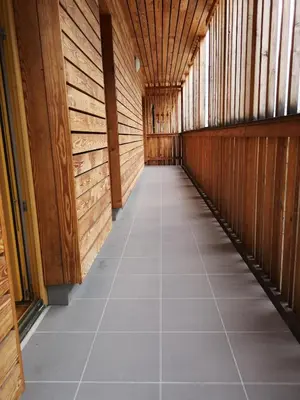 a hallway with wooden walls and a tiled floor at Apartma Lucijana in Mojstrana