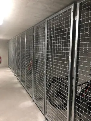 a row of metal cages in a building at Villa Mojca - Apartment Peridot in the Center with Private Indoor Parking in Kranjska Gora