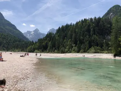 a group of people on a beach near a river at Villa Mojca - Apartment Peridot in the Center with Private Indoor Parking in Kranjska Gora