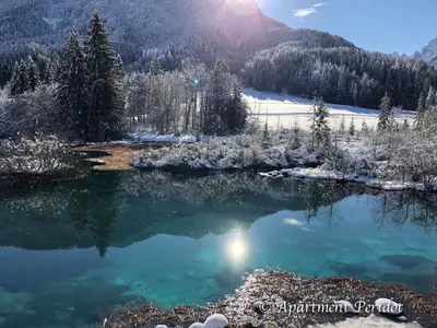 a pool of water in the middle of a snow covered mountain at Villa Mojca - Apartment Peridot in the Center with Private Indoor Parking in Kranjska Gora