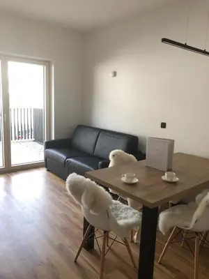 a living room with a table and a couch at Villa Mojca - Apartment Peridot in the Center with Private Indoor Parking in Kranjska Gora