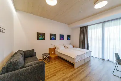 a bedroom with a bed and a couch at WUD hotel in Ljubljana