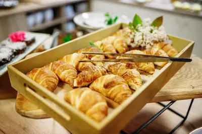 a box of croissants and other pastries on a table at WUD hotel in Ljubljana