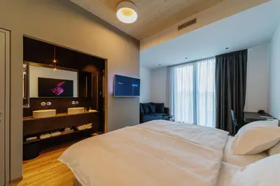 a bedroom with a bed and a sink and a mirror at WUD hotel in Ljubljana