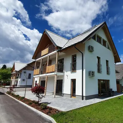 a white building with a gambrel roof at Deluxe apartments Bled in Bled