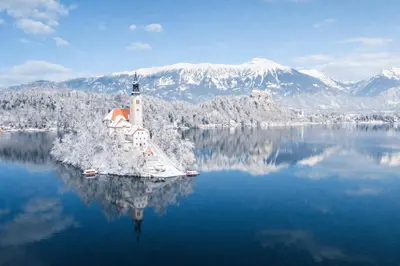 a lighthouse in the middle of a body of water at Deluxe apartments Bled in Bled