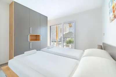 two beds in a white room with a window at Deluxe apartments Bled in Bled