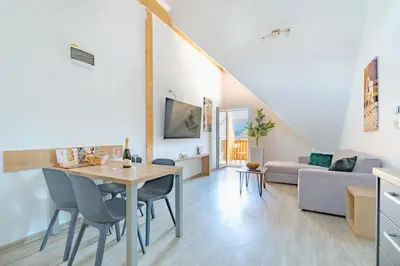 a dining room and living room with a table and chairs at Deluxe apartments Bled in Bled