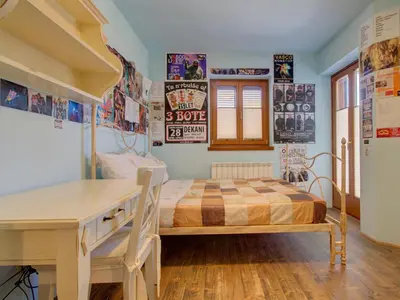 a bedroom with a bed and a desk in it at Family Apartment Rihter in Črni Kal