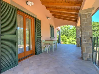 an outdoor patio with a wooden door and a table at Family Apartment Rihter in Črni Kal