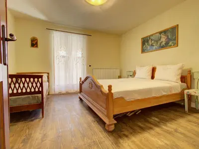 a bedroom with a large bed and a window at Family Apartment Rihter in Črni Kal