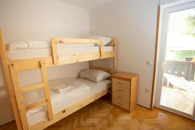 a bedroom with two bunk beds and a window at Hostel LakeBled in Bled